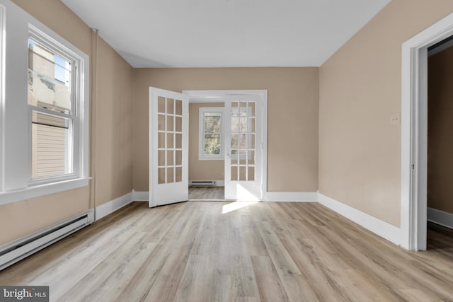 empty room featuring french doors, a baseboard radiator, and light wood-type flooring