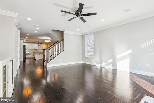 unfurnished living room featuring ornamental molding, ceiling fan, and dark hardwood / wood-style floors