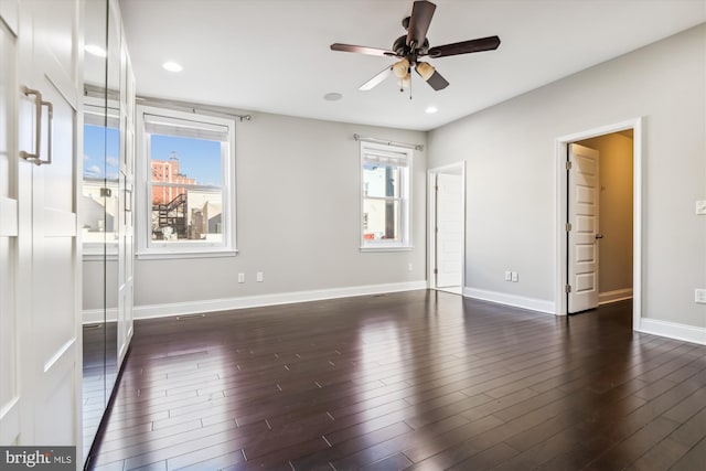 interior space with dark wood-type flooring, ceiling fan, and multiple windows