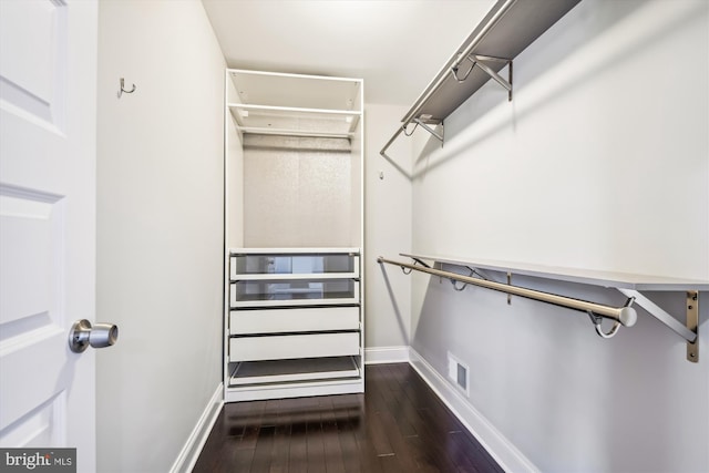 walk in closet with dark hardwood / wood-style floors