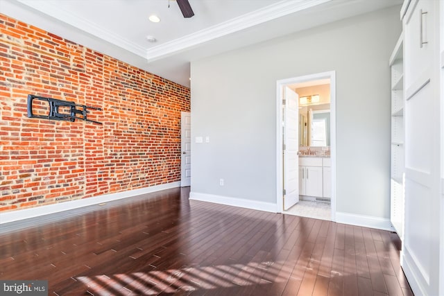 interior space featuring light wood-type flooring, ceiling fan, crown molding, and brick wall