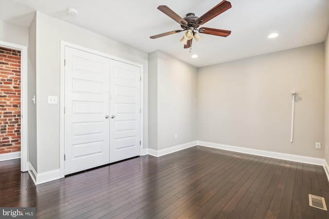 unfurnished bedroom with dark hardwood / wood-style flooring, a closet, and ceiling fan