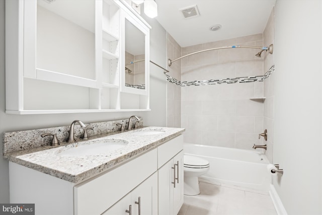 full bathroom featuring vanity, tile patterned flooring, toilet, and tiled shower / bath combo