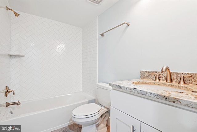 full bathroom featuring tiled shower / bath, vanity, and toilet