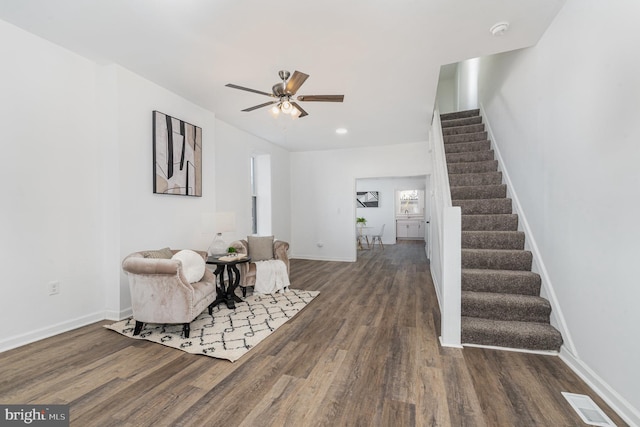 living area with ceiling fan and dark wood-type flooring