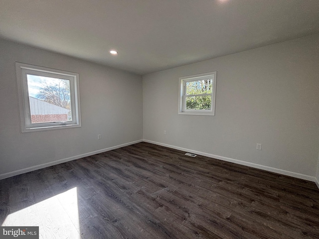 unfurnished room with dark wood-type flooring