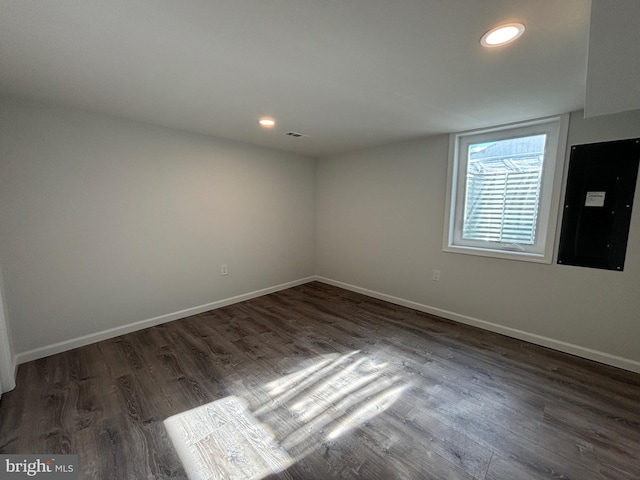 empty room featuring dark hardwood / wood-style flooring and electric panel