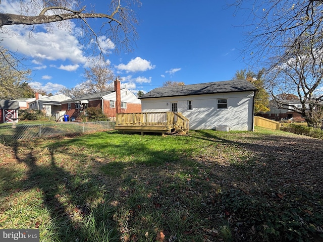 back of house with a lawn and a deck