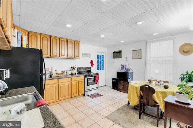 kitchen with black fridge, a wall mounted AC, sink, electric stove, and light tile patterned flooring