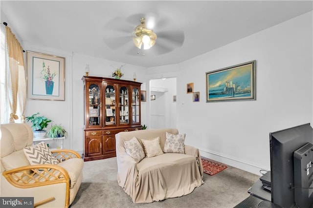 carpeted living room with ceiling fan