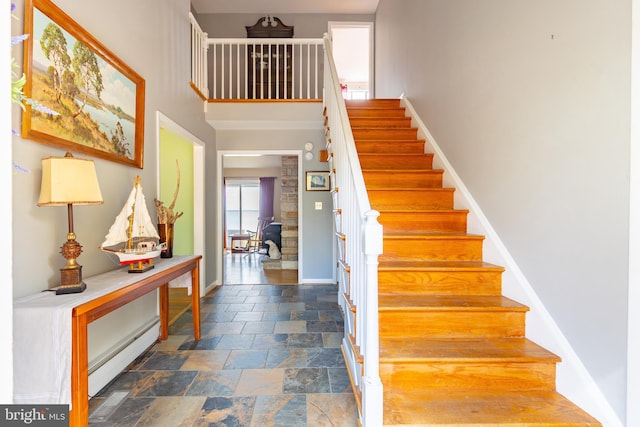 stairs featuring a wood stove and a baseboard radiator