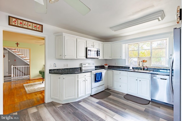 kitchen featuring white cabinets, appliances with stainless steel finishes, light hardwood / wood-style flooring, and sink