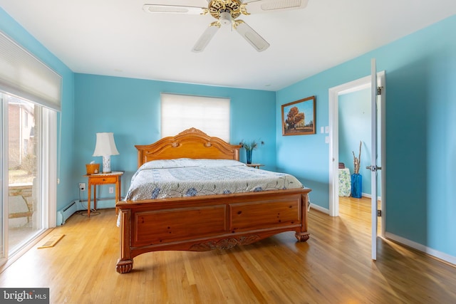 bedroom featuring a baseboard radiator, light hardwood / wood-style flooring, and ceiling fan