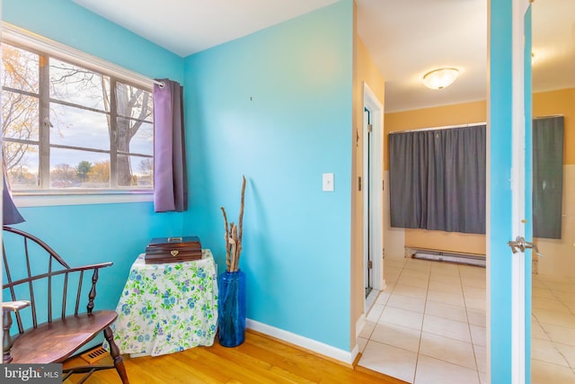 sitting room featuring a baseboard heating unit and light hardwood / wood-style flooring