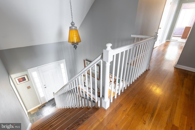 staircase featuring hardwood / wood-style flooring and high vaulted ceiling