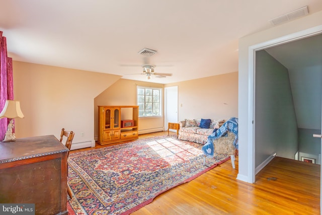 living room featuring a baseboard heating unit, ceiling fan, vaulted ceiling, and hardwood / wood-style flooring