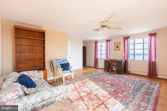 living room with ceiling fan, a baseboard radiator, and light hardwood / wood-style flooring