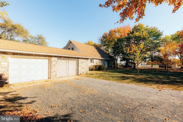 view of side of home with a garage and a yard