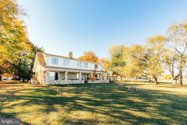 rear view of property featuring a lawn