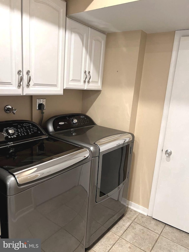 16 Stonehenge Cir Unit 16-5, Pikesville, MD 21208 - laundry area with cabinet space, washing machine and dryer, and baseboards