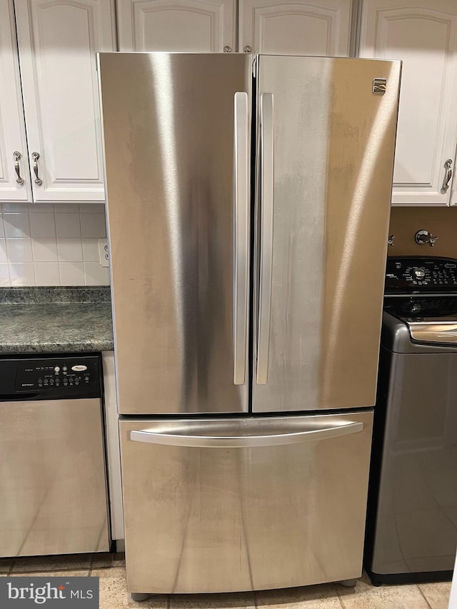 kitchen featuring white cabinetry, appliances with stainless steel finishes, backsplash, and washer / dryer