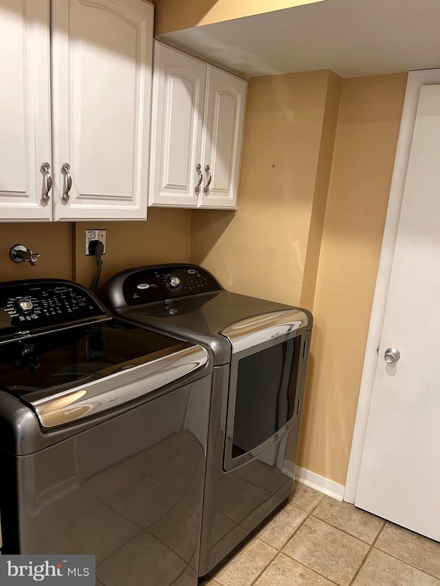 laundry room with washing machine and dryer and cabinets