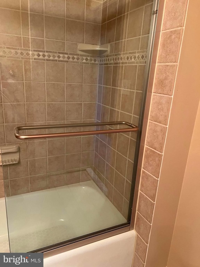 bathroom with shower / bath combination with glass door