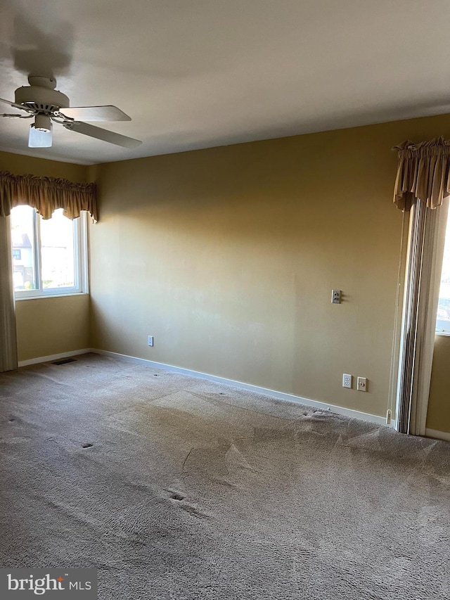 carpeted spare room with ceiling fan