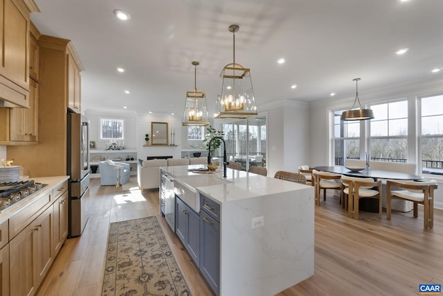 kitchen featuring light wood-type flooring, hanging light fixtures, and light stone countertops