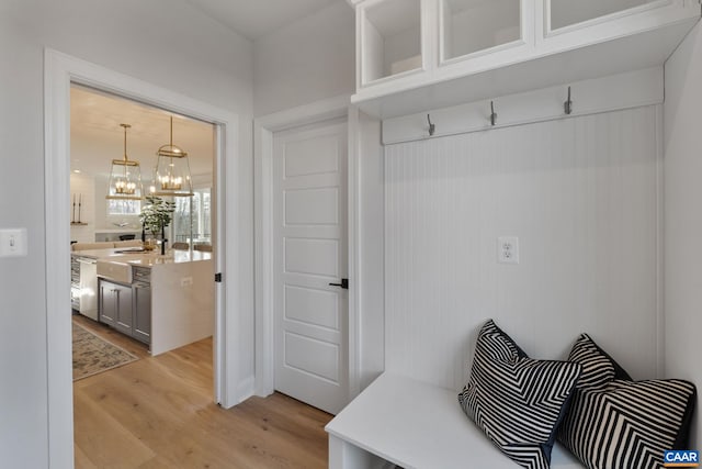 mudroom featuring sink, light hardwood / wood-style flooring, and a notable chandelier