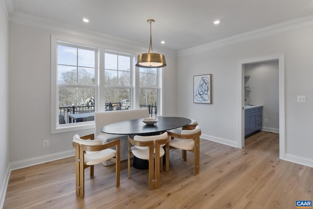 dining area with light hardwood / wood-style flooring and ornamental molding