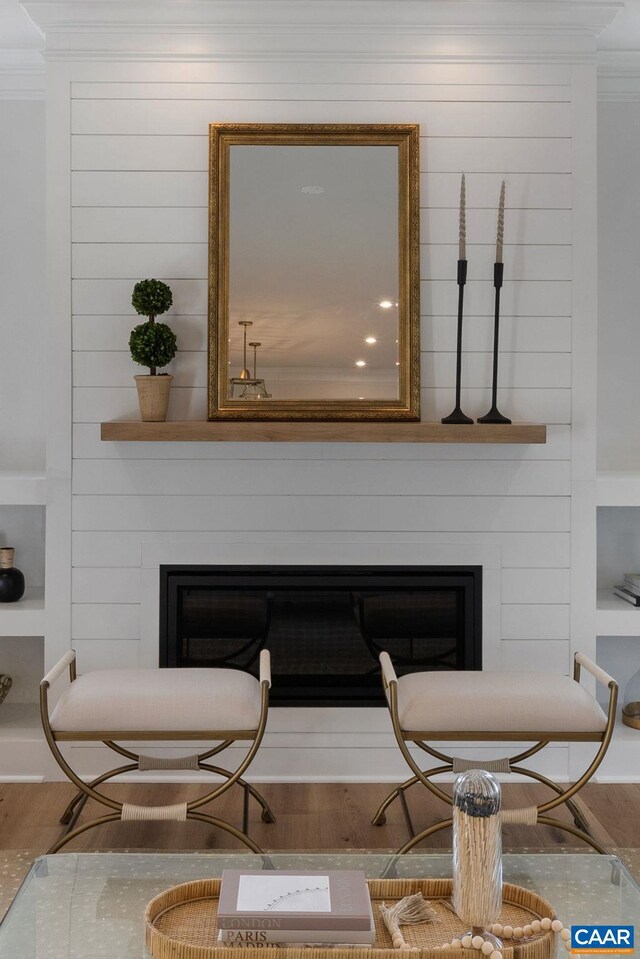 living area featuring a fireplace, wood-type flooring, and wood walls