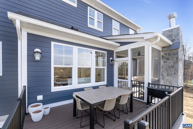 deck with ceiling fan and a sunroom