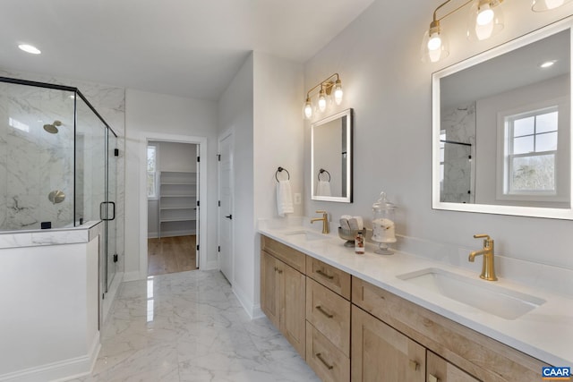 bathroom featuring a shower with shower door and vanity