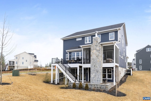 back of property featuring a sunroom, a deck, a patio area, central air condition unit, and a lawn