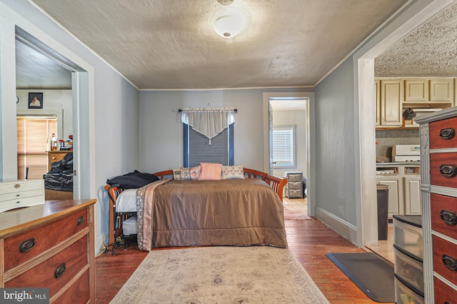 bedroom featuring ornamental molding, a textured ceiling, and dark wood-type flooring