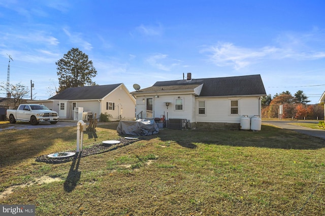 view of front of house featuring central AC unit and a front lawn