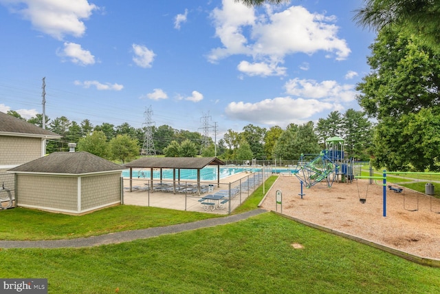 view of pool featuring a playground and a lawn