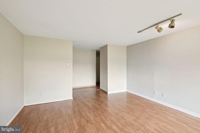 spare room with light hardwood / wood-style floors and track lighting