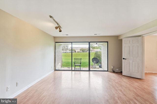 unfurnished room featuring light wood-type flooring and rail lighting