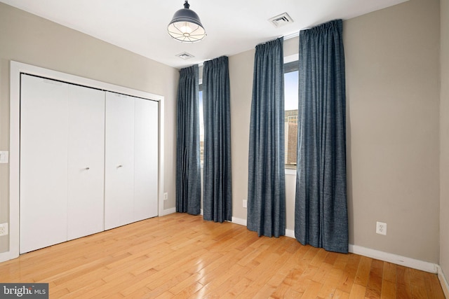 unfurnished bedroom with a closet and hardwood / wood-style floors