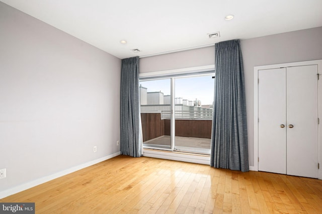 empty room with hardwood / wood-style flooring