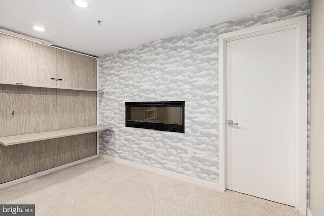 unfurnished living room featuring a large fireplace and light colored carpet