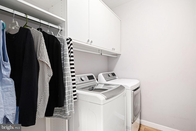 laundry room featuring washing machine and dryer and cabinets