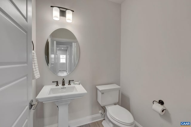 bathroom featuring hardwood / wood-style flooring and toilet