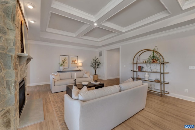 living room with light wood-type flooring, a fireplace, and crown molding