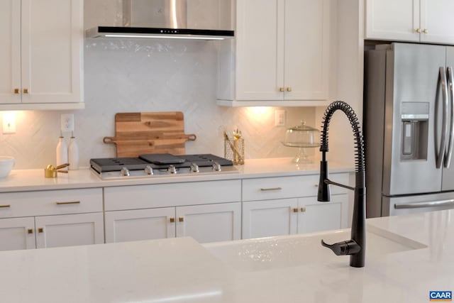 kitchen featuring extractor fan, appliances with stainless steel finishes, and white cabinetry