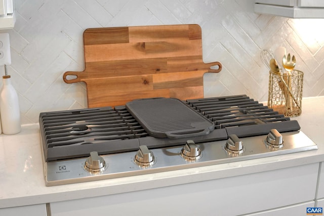 details with stainless steel gas cooktop and backsplash