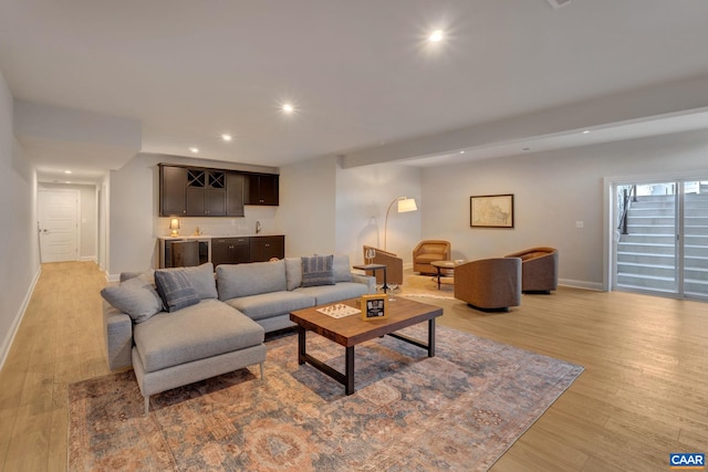 living room with light hardwood / wood-style floors and wet bar