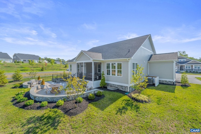 view of front of house featuring a front yard, a sunroom, a patio, and cooling unit